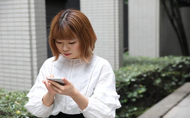 女性がスマートフォンを見ているイメージ画像